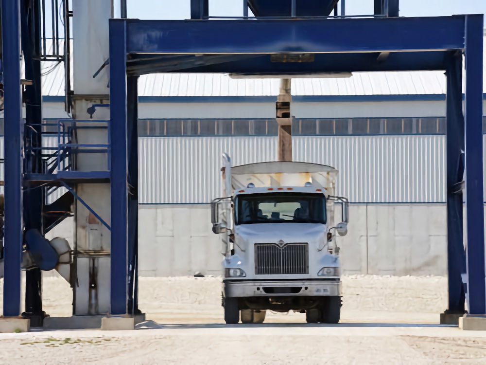 A transport truck being filled with fertilizer