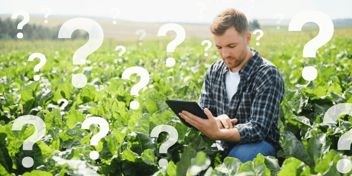 Photo of man in field holding tablet surrounded by question marks
