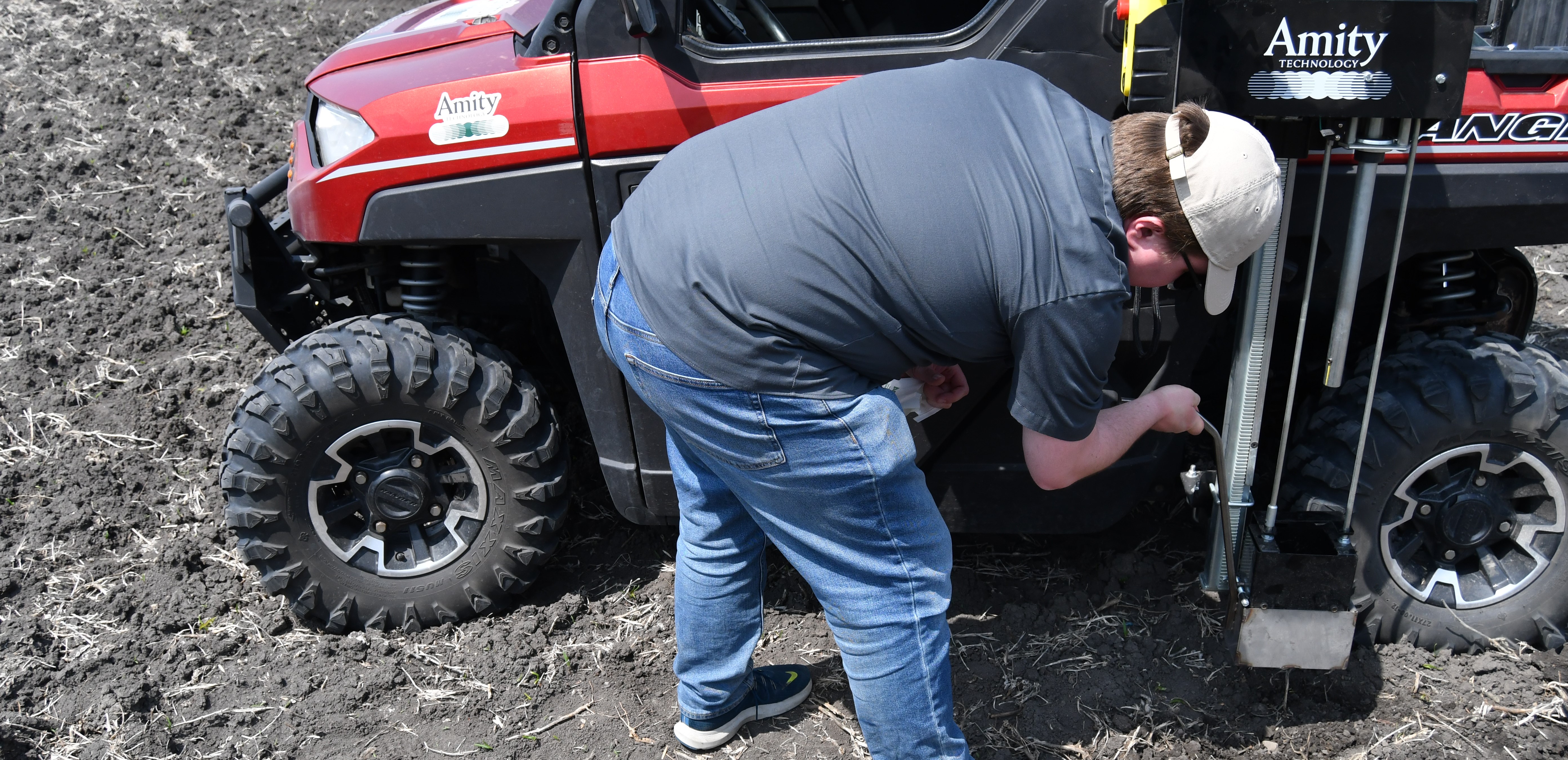 A man utilizing an Amity Technology Soil Sampler mounted on a Utility Task Vehicle.